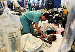 ポルトープランスの病院で地震で負傷した子どもの様子を見る看護師。