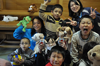 宮城県石巻市の青葉中学校の避難所に設置された「子どもにやさしい空間」で遊ぶ子どもたちと井本さん（左）。