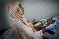 © UNICEF/NYHQ2011-1222/Holt ソマリアにある病院で娘の手を握る母親。