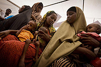 © UNICEF/NYHQ2011-1344/Holt 避難キャンプで深刻な栄養不良に陥っている子どもの診察の順番を待つ女性たち。