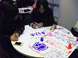 ポスター作り(写真左)と出来上がったポスターを手に記念撮影