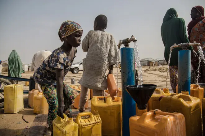 ナイジェリアの国内避難民キャンプで水を汲む女性